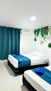 2 camas en una habitación con cortinas azules en Marbar Cartagena Hostel, en Cartagena de Indias
