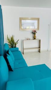 a blue couch in a living room with a table at Marbar Cartagena Hostel in Cartagena de Indias