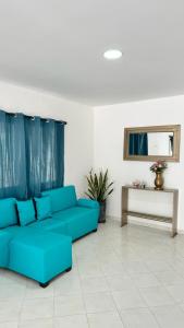 Sofá azul en la sala de estar con mesa en Marbar Cartagena Hostel, en Cartagena de Indias