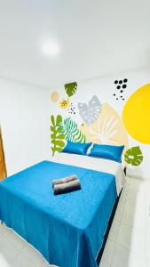 a bedroom with a bed with blue sheets and a mural at Marbar Cartagena Hostel in Cartagena de Indias