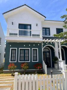 a white fence in front of a house at Novaworld Phan Thiết The Blue Villa in Bình Tú