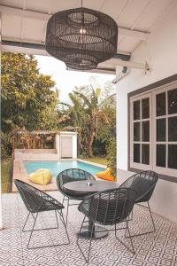 un patio con mesa, sillas y piscina en Villa Sky By The Villas 100 en Cisarua