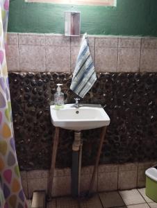 a bathroom sink with an umbrella on top of it at El Güis hostel in Balgue +50 photos