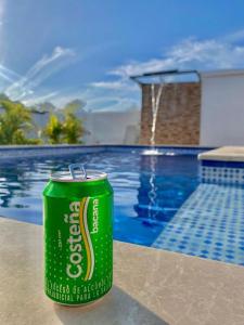 a green can of beer sitting next to a pool at HERMOSA CASA FINCA EN TURBACO in Turbaco