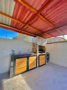 an outdoor kitchen with wooden cabinets and a roof at HERMOSA CASA FINCA EN TURBACO in Turbaco