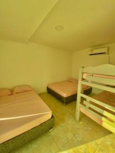 two beds in a room with two bunk beds at HERMOSA CASA FINCA EN TURBACO in Turbaco