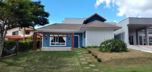une maison avec une porte bleue et une cour dans l'établissement Minha Casinha Azul na Represa, à Paranapanema
