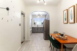 a kitchen and dining room with a table and a refrigerator at 4 Bedroom Sun Drenched & Designer Home in Brooklyn