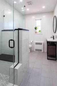 a bathroom with a glass shower and a toilet at 4 Bedroom Sun Drenched & Designer Home in Brooklyn