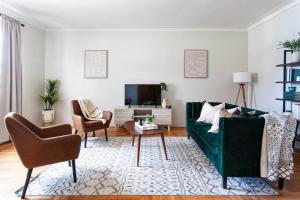 uma sala de estar com um sofá verde e uma televisão em 4 Bedroom Sun Drenched & Designer Home em Brooklyn
