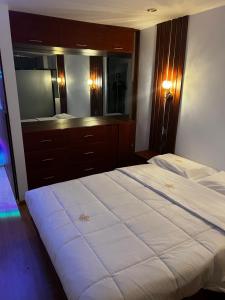 1 dormitorio con 1 cama grande y espejo grande en Hotel SOGU TOWER, en Ayacucho