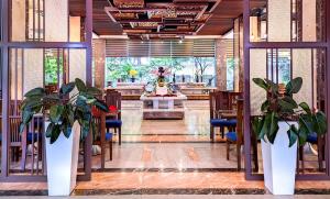 un restaurante con mesas y macetas en una habitación en Muong Thanh Grand Xa La Hotel, en Hanói