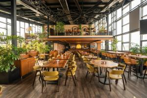 a restaurant with tables and chairs and plants at Hotel Le Grandeur in Narasimharaja Puram