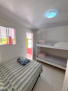 a bedroom with a bed and two bunk beds at Hostel e Pousada Jacumã in Conde
