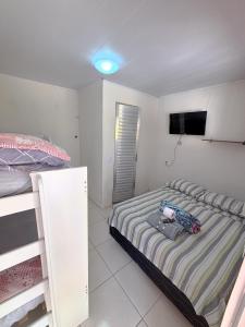 a bedroom with two bunk beds and a flat screen tv at Hostel e Pousada Jacumã in Conde