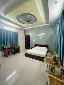 - une chambre avec un lit, un bureau et une table dans l'établissement HOMESTAY BỜ HỒ CẦN THƠ, à Cần Thơ