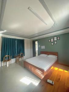 - une chambre avec un lit, une table et des chaises dans l'établissement HOMESTAY BỜ HỒ CẦN THƠ, à Cần Thơ