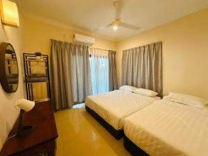 ein Hotelzimmer mit 2 Betten und einem Fenster in der Unterkunft Landed 4BR 11PAX Near Airport KK in Putatan