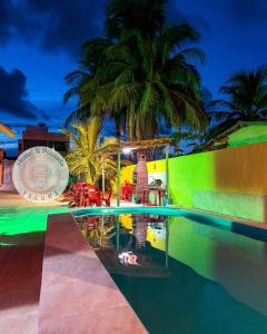 a swimming pool at a resort with palm trees at Hostel e Pousada Jacumã in Conde