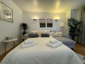 a bedroom with a large white bed and a couch at Luxury Apartment in Canary Wharf in London