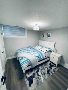 a small bedroom with a bed and a night stand at Cozy*Bright*Modern 2 Bedroom guest suite in Edmonton