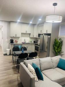 a living room with a couch and a table and a kitchen at Cozy*Bright*Modern 2 Bedroom guest suite in Edmonton