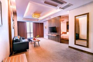 a living room with a couch and a television at Muong Thanh Grand Xa La Hotel in Hanoi