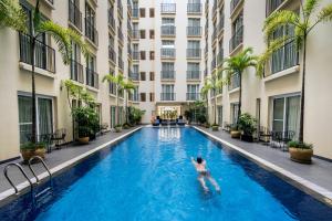 a man swimming in a swimming pool in a building at Central Mansions Serviced Apartments in Phnom Penh
