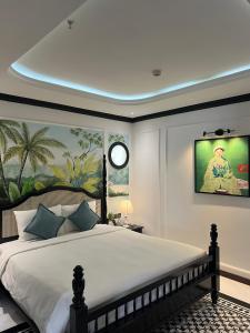 una camera da letto con un grande letto con un orologio sul muro di Mercy Emerald Hotel a Da Nang