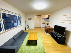 a living room with a blue couch and a table at Hirafu House 8 in Kutchan