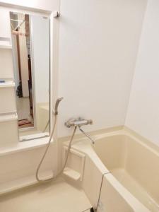 una bañera con una manguera conectada a un lavabo en Hirafu House 8 en Kutchan