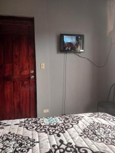 a bedroom with a bed and a tv on the wall at Habitación el mirador in San Rafael