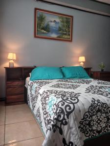 a bedroom with a bed with a black and white comforter at Habitación el mirador in San Rafael