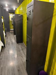 - une rangée de casiers dans un dortoir aux murs jaunes dans l'établissement Patio Hangar Toluca Aeropuerto (antes BoxPark), à Toluca