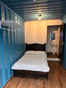a bed in a room with a blue wall at Patio Hangar Toluca Aeropuerto (antes BoxPark) in Toluca