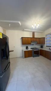 eine Küche mit Holzschränken und einem Kühlschrank aus Edelstahl in der Unterkunft Departamento moderno con gran espacio in Cuenca