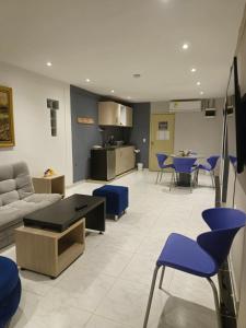 sala de estar con sofá y sillas azules en Hostel Boutique Musa Paradisiaca en Santa Marta