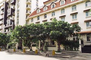 una fila de árboles frente a un edificio en Central Mansions Serviced Apartments en Phnom Penh