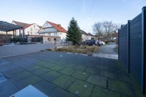 um parque de estacionamento vazio com uma cerca e casas em Exklusive Stadtwohnung im EG em Bad Lippspringe
