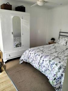 een slaapkamer met een bed, een dressoir en een spiegel bij Beautiful 1 bedroom cottage on 1 acre in Sandford