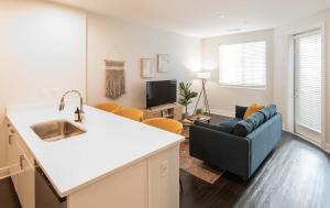 cocina y sala de estar con sofá y lavamanos en Cozysuites l Luxe 1BR in Downtown Cincinnati, en Cincinnati