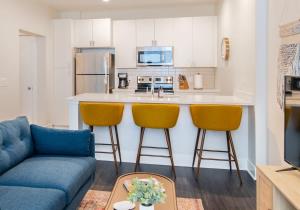 a living room with a couch and a kitchen at Cozysuites l Luxe 1BR in Downtown Cincinnati in Cincinnati