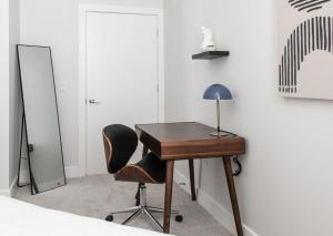 a bedroom with a desk and a chair and a mirror at CozySuites Stunning 3BR in Downtown Cincinnati in Cincinnati +35 photos