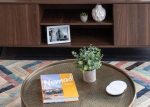 a coffee table with a magazine and a plant on it at Cozysuites l Luxe 2BR in Downtown Cincinnati in Cincinnati