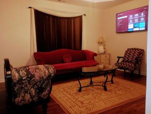 a living room with a red couch and two chairs at Luxury Suite in Austell