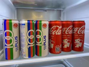 una fila de latas de cocacola en un refrigerador en 139 Homestay 13 Mins From kuching Airport Baby Friendly Spacious Home, en Kota Samarahan