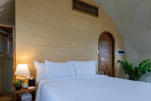 a bedroom with a white bed and a brick wall at Wonderland Resort Phan Thiet in Phan Thiet