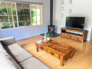 a living room with a couch and a coffee table at Farmhouse in the heart of wine country, 10 minutes to beach in Hastings