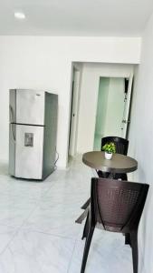 a table and chair in a room with a refrigerator at Apartamento Marbar 1 in Cartagena de Indias