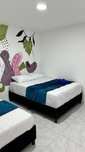 a bedroom with two beds and a mural on the wall at Apartamento Marbar 1 in Cartagena de Indias